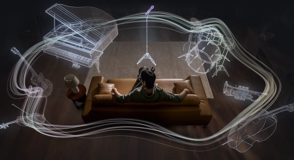 Mężczyzna na kanapie otoczony zarysem instrumentów 360 Audio: mikrofon, perkusja, trąbka, wiolonczela, skrzypce, gitara, fortepian.