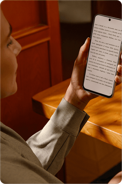Osoba trzymająca smartfon z czytanym tekstem oraz logo certyfikatu TÜV Rheinland w górnym rogu