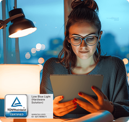 Kobieta korzystająca z tabletu wieczorem i certyfikat Low Blue Light.