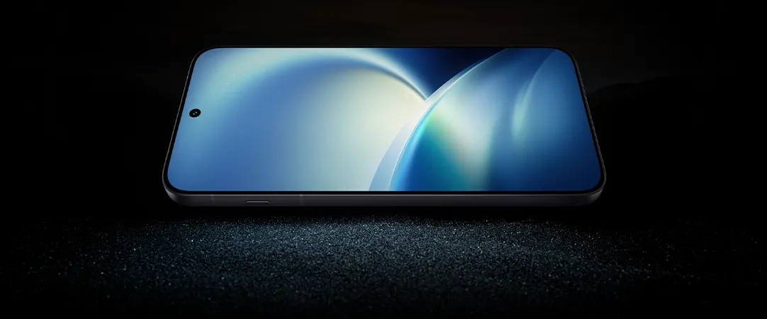 Smartfon ułożony poziomo, z cienkimi ramkami i niebieską tapetą na ekranie, na ciemnym podłożu.